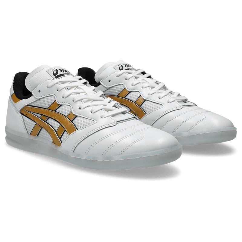 White sneakers with gold accents on a black background