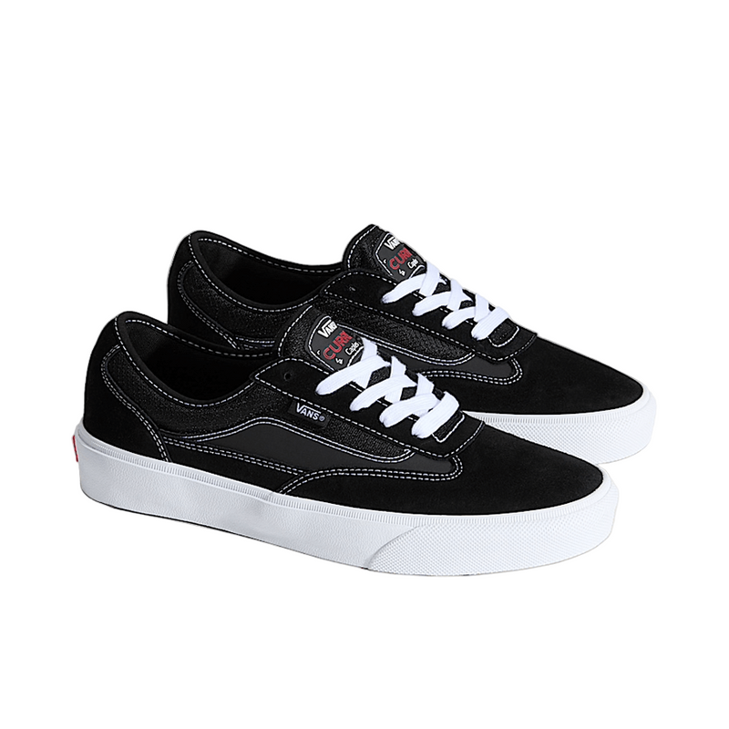 Black sneakers with white soles on a light gray background