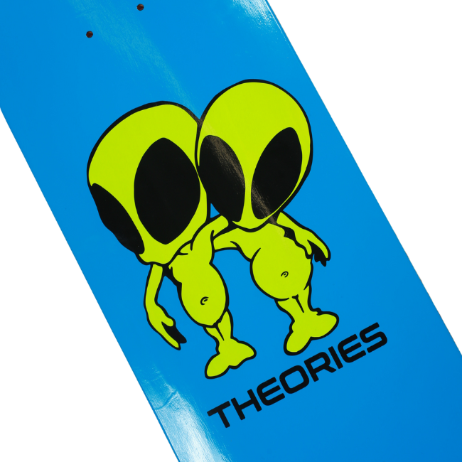 Skateboard deck with green aliens and 'Theories' branding on a blue background